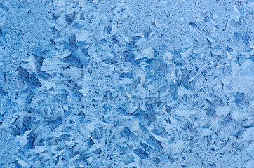 Fototapeta na wymiar Frost snowflakes on window glass texture background