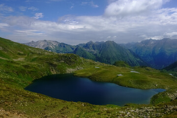 Fototapeta na wymiar gorgeous blue mountain lake in green hills with little ponds