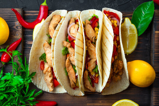  Latin American Tacos With Chicken And Corn On A Wooden Board And A Black Background Close Up