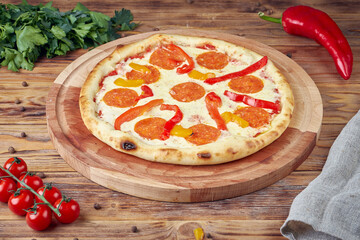Pizza with meat, vegetables and mushrooms, wooden background