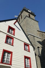 Fototapeta na wymiar Emporragender Kirchturm Aukloster mit Hausfassade in Monschau / Eifel