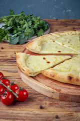 Pizza with meat, vegetables and mushrooms, wooden background