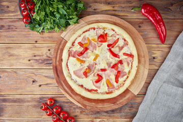Pizza with meat, vegetables and mushrooms, wooden background