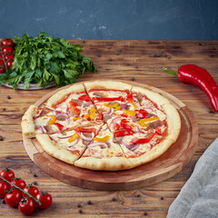 Pizza with meat, vegetables and mushrooms, wooden background