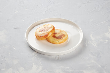 Two cheesecakes on a plate, concrete background, for the designer