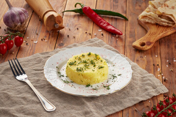 Plate with mashed potatoes on wooden background