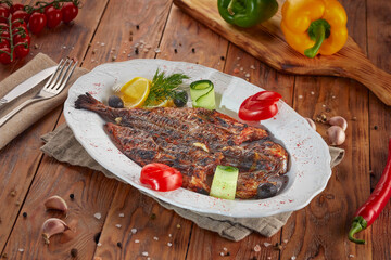 Grilled sea bass fish with lemon, wooden background