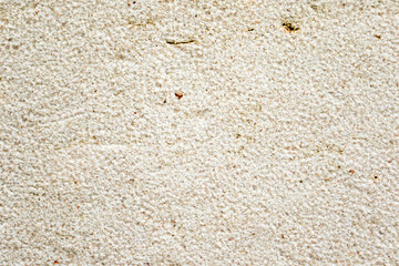 Apply sand rubbing plaster to masonry on concrete. Scratched and cracked dirty weathered sand textured plaster surface texture.