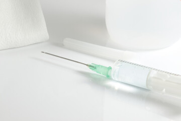 Syringe prepared with the needle to be injected, along with sterile gauze and disinfectant alcohol.