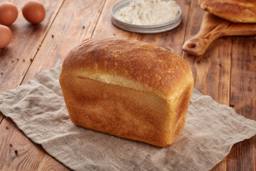 Wheat flour bread, wooden background
