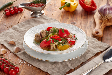 Lamb khashlama with vegetables, wooden background