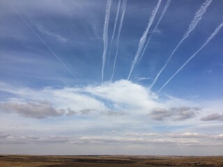 plane tracks in the sky over the field