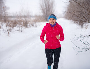 running woman in red sportswear in winter season