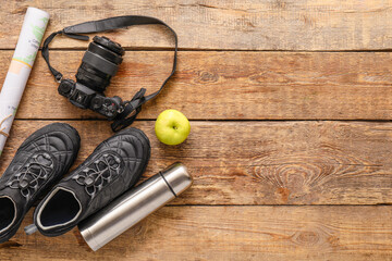 Items and shoes for hiking on wooden background