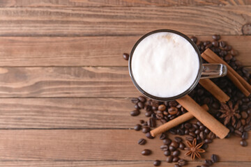Tasty coffee with cinnamon in cup on wooden background