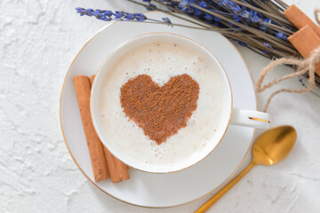 Tasty coffee with cinnamon in cup on light background
