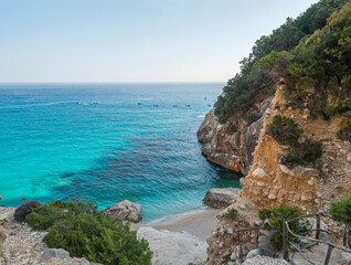 A view of empty Cala Goloritze beach with white pebbles limestone rock and turquoise blue water. Famous travel destination. Gulf of Orosei, Sardinia, Italy, September