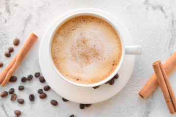 Obraz na płótnie Canvas Tasty coffee with cinnamon in cup on light background