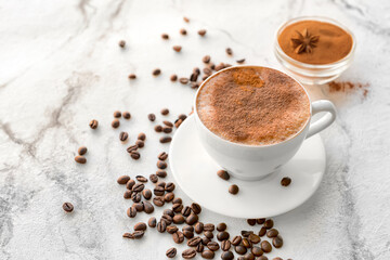 Tasty coffee with cinnamon in cup on light background