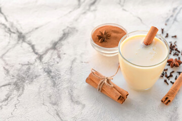 Obraz na płótnie Canvas Tasty milkshake with cinnamon in glass on light background
