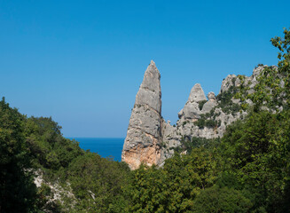 A view of limestone rock pillar Aguglia at Cala Goloritze beach at Gulf of Orosei. Famous travel destination. Sardinia, Italy, September
