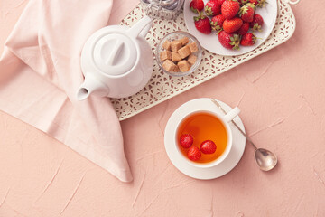Composition with cup of hot strawberry tea on color background