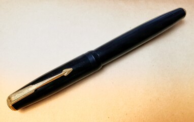 Closeup photo on gold fountain pen and old book background