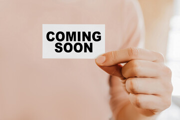 Man holding a business card with Coming Soon
