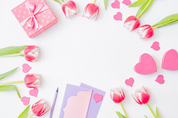 Obraz premium Flat lay valentines day frame with pink tulips and gift box on a white background