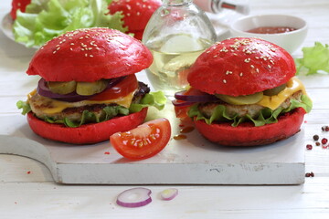 Burgers with red buns and chicken cutlet on a white plate