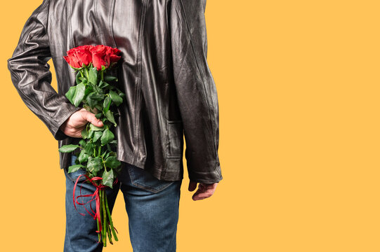 Man With A Bouquet Of Red Roses Behind His Back. Elegant Man Holding Red Rose Flowers In Hand.