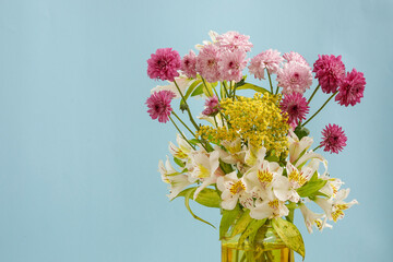 Arreglo floral con un fondo de color azul. Concepto decoración de interiores