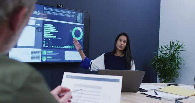Diverse business colleagues sitting listening to presentation in office meeting