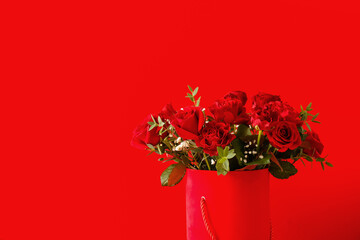 Gift box with beautiful flowers on color background