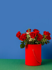 Gift box with beautiful flowers on color background