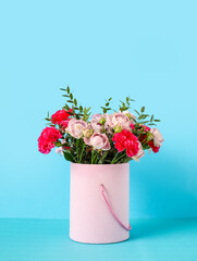 Gift box with beautiful flowers on color background