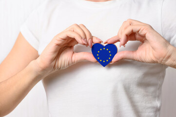 Love European Union. The girl holds a heart in the form of the flag of EU on her chest. European patriotism concept