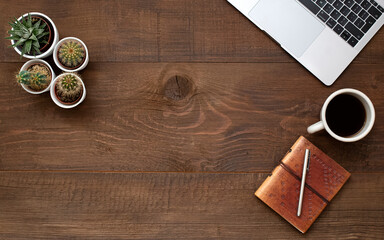 .Laptop, coffee, pen and notebook on old wooden table with copy space.