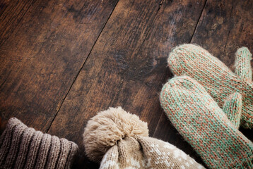 A set of fashionable winter clothes Knitted sweater hat and gloves on wooden background with copy space