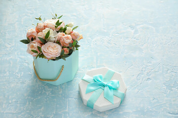 Gift box with beautiful flowers on color background