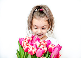 Portrait of a beautiful smiling little girl with spring tulips on a white background. International Women's Day. Girl 5 years old, Caucasian. Isolated.