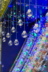 Electric garlands glowing on the counter of the store. Small lamps for sale. Christmas lights.