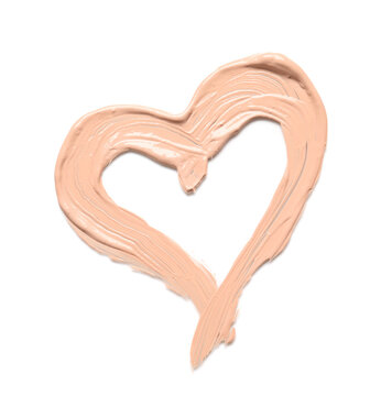 Heart made of makeup foundation on white background