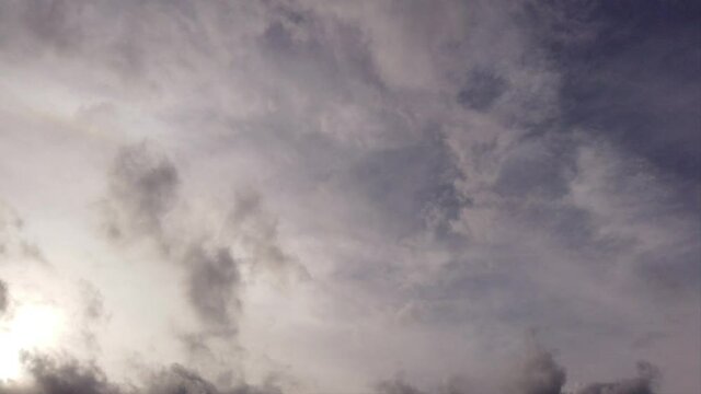Sunrise sky in time lapse with fluffy cirrus floccus clouds moving fast over filaments of cirrostratus motion background