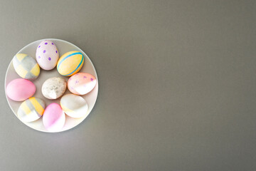 Easter eggs on a gray plate on a gray background with place for text. View from above
