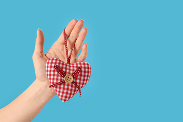 Hand with decorative heart on color background