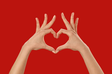Hands making heart on color background