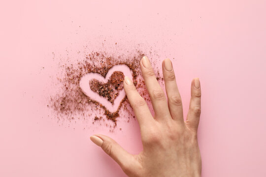 Hand and heart made of powder on color background