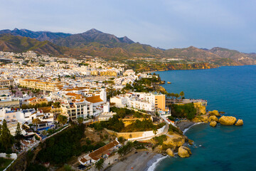 Panoramic aerial view of Nerja city by Mediterranean coast on sunny day, Costa del Sol, Spain