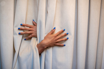 Close up shot of hands protruding from behind curtain